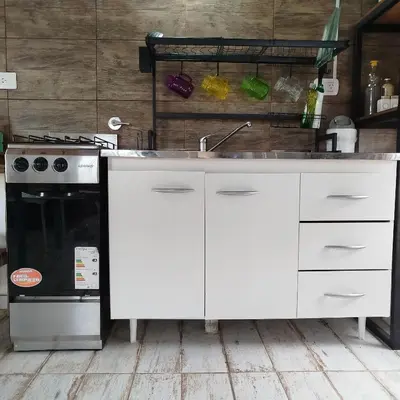 a white kitchen with a sink and a stove at Entre Tanto in Luyaba