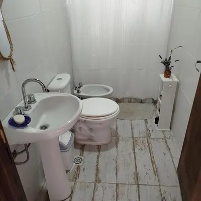 a white bathroom with a sink and a toilet at Entre Tanto in Luyaba