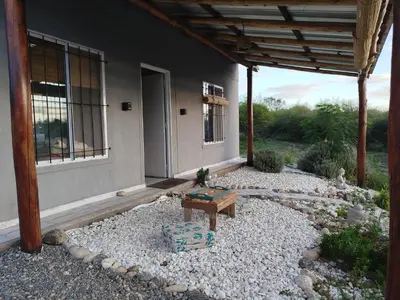 a patio with a bench in front of a house at Entre Tanto in Luyaba