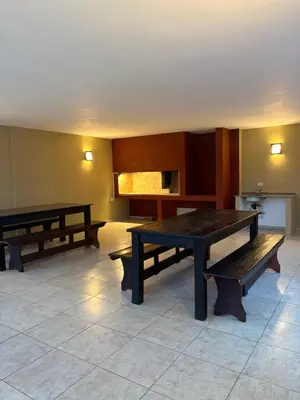 a room with two tables and benches in it at Amelia 2-1 in Villa Carlos Paz