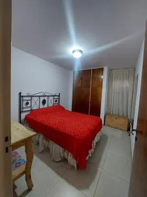 a bedroom with a red bed with a red blanket at Apartment in Nueva Córdoba for you! in Cordoba