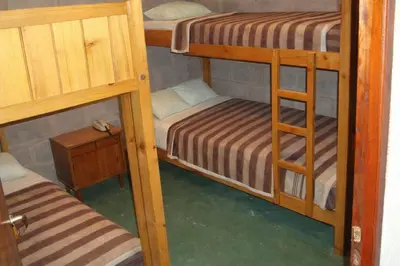 a room with two bunk beds and a table at Casa de Campo con Pileta - Estancia La Amistad in Villa Santa Cruz del Lago