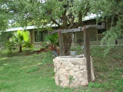 a stone fountain in the yard of a house at Casa de Campo con Pileta - Estancia La Amistad in Villa Santa Cruz del Lago