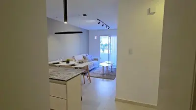 a kitchen and living room with a table and a couch at Hostel del carlos in Villa Carlos Paz