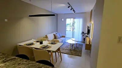 a kitchen and living room with a table and chairs at Hostel del carlos in Villa Carlos Paz