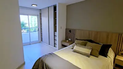 a bedroom with a large bed and a balcony at Hostel del carlos in Villa Carlos Paz