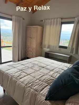 a bedroom with a large bed and a window at L&M Cabañas Villa Yacanto in Villa Yacanto