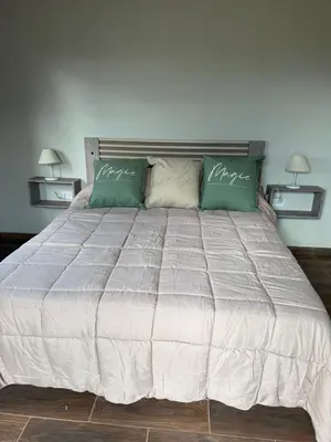 a bedroom with a large bed with two pillows at L&M Cabañas Villa Yacanto in Villa Yacanto