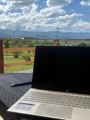 a laptop computer sitting on top of a table at L&M Cabañas Villa Yacanto in Villa Yacanto