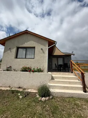 a house with stairs leading up to a house at L&M Cabañas Villa Yacanto in Villa Yacanto