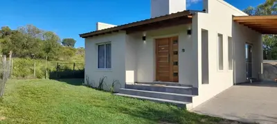 a small white house with a wooden door at Casa los nonos in Cordoba