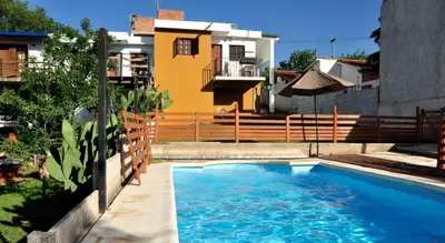a swimming pool in front of a house at Carlos Paz Casa con pileta cerca Río y Centro in Villa Carlos Paz