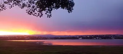 a sunset over a body of water with the sky at Carlos Paz Casa con pileta cerca Río y Centro in Villa Carlos Paz