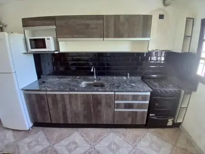 a kitchen with a sink and a stove at Carlos Paz Casa con pileta cerca Río y Centro in Villa Carlos Paz