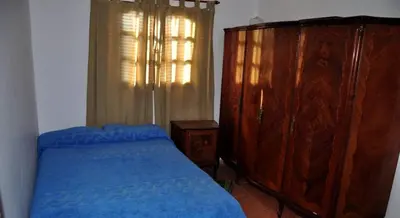 a bedroom with a blue bed and a wooden dresser at Carlos Paz Casa con pileta cerca Río y Centro in Villa Carlos Paz