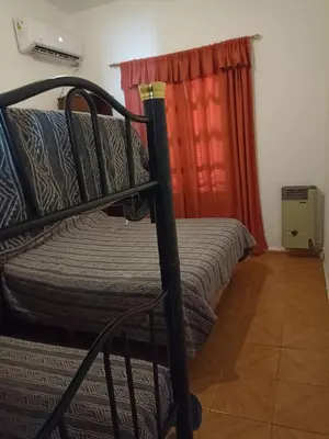a bunk bed in a room with a red curtain at Carlos Paz Casa con pileta cerca Río y Centro in Villa Carlos Paz