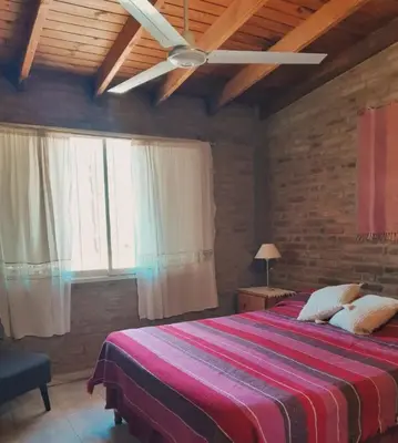 a bedroom with a bed and a ceiling fan at Bajos de Nono in Nono