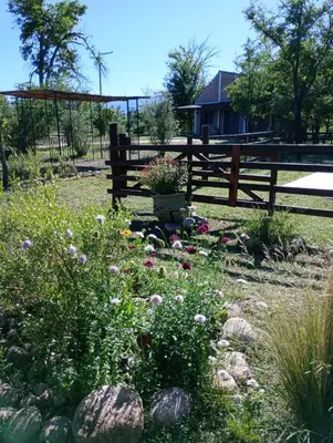 a park with a bench and a garden with flowers at Bajos de Nono in Nono