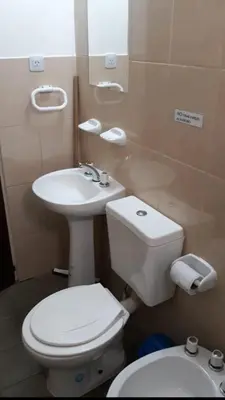 a bathroom with a white toilet and a sink at Postal Serrana 1 in Villa Cura Brochero