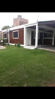 a house with a green lawn in front of it at Postal Serrana 1 in Villa Cura Brochero