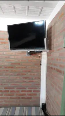 a flat screen tv on top of a brick wall at Postal Serrana 1 in Villa Cura Brochero
