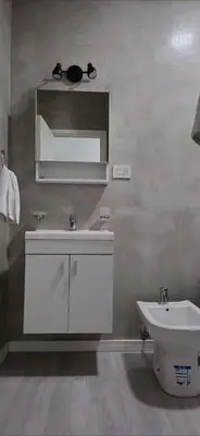 a bathroom with a sink and a toilet and a mirror at Departamento Céntrico Margarita - Villa Carlos Paz in Villa Carlos Paz
