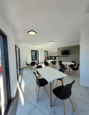 a room with tables and chairs and a kitchen at Departamento Céntrico Margarita - Villa Carlos Paz in Villa Carlos Paz