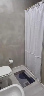 a bathroom with a toilet and a shower curtain at Departamento Céntrico Margarita - Villa Carlos Paz in Villa Carlos Paz