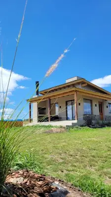 a house with a sprinkler in front of it at Las Tacuaritas in Villa Ciudad Parque