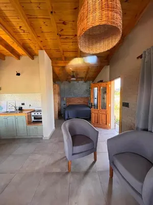 a living room with a couch and chairs and a kitchen at Las Tacuaritas in Villa Ciudad Parque
