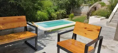 two benches sitting next to a swimming pool at Homer Renata Goethe 1197 Villa Carlos Paz, Córdoba in Villa del Lago