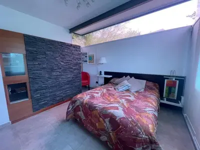 a bedroom with a bed and a large window at Homer Renata Goethe 1197 Villa Carlos Paz, Córdoba in Villa del Lago