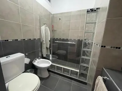 a small bathroom with a toilet and a shower at Homer Renata Goethe 1197 Villa Carlos Paz, Córdoba in Villa del Lago