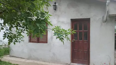 a white building with a door and two windows at Los árboles in Potrero de Garay