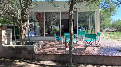 a group of chairs and tables in front of a building at Bosquesito in Mina Clavero