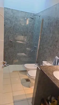 a bathroom with a glass shower and a toilet at Bosquesito in Mina Clavero