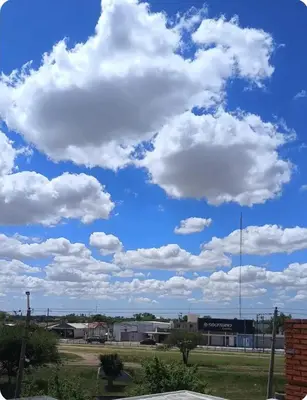 a blue sky with white clouds in a parking lot at Depto wifi rápido con grandes espacios verdes in Río Tercero