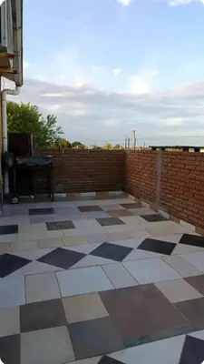 a patio with a brick wall and a tile floor at Depto wifi rápido con grandes espacios verdes in Río Tercero
