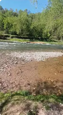 a river with rocks and trees in the background at Depto wifi rápido con grandes espacios verdes in Río Tercero