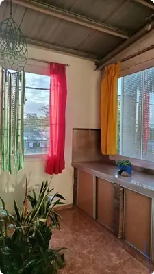 a room with two windows with red and yellow curtains at Depto wifi rápido con grandes espacios verdes in Río Tercero