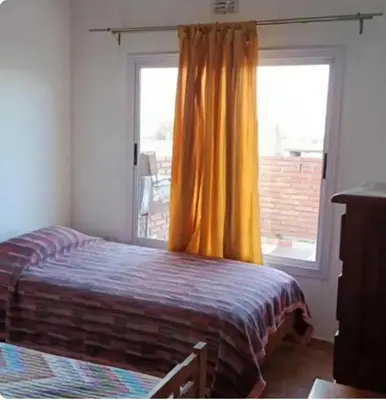 a bedroom with a bed in front of a window at Depto wifi rápido con grandes espacios verdes in Río Tercero