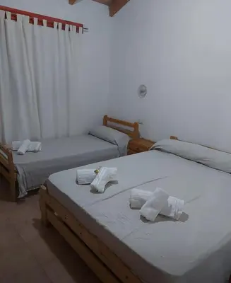 two beds in a room with towels on them at Hosteria Rivadavia in Mina Clavero
