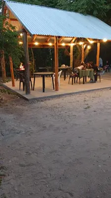 a group of people sitting at tables in a pavilion at Hosteria Rivadavia in Mina Clavero
