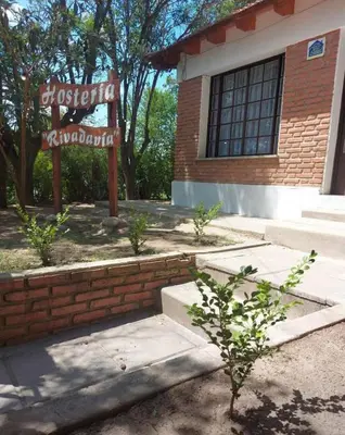 a brick building with a sign in front of it at Hosteria Rivadavia in Mina Clavero