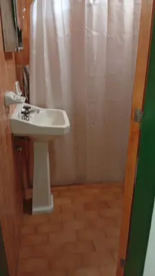 a bathroom with a sink and a shower curtain at Hosteria Rivadavia in Mina Clavero