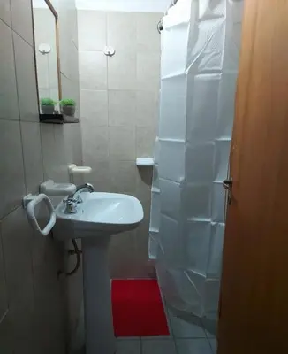 a white bathroom with a sink and a mirror at Hosteria Rivadavia in Mina Clavero