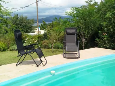 two chairs sitting next to a swimming pool at Ohana in Potrero de Garay