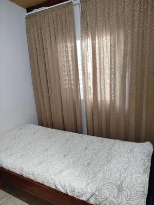a bedroom with a bed with curtains and a window at Ohana in Potrero de Garay