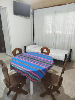 a table with two chairs and a bed in a room at Ohana in Potrero de Garay