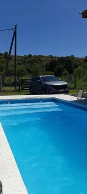 a car parked next to a blue swimming pool at Casa los nonos in Cavalango